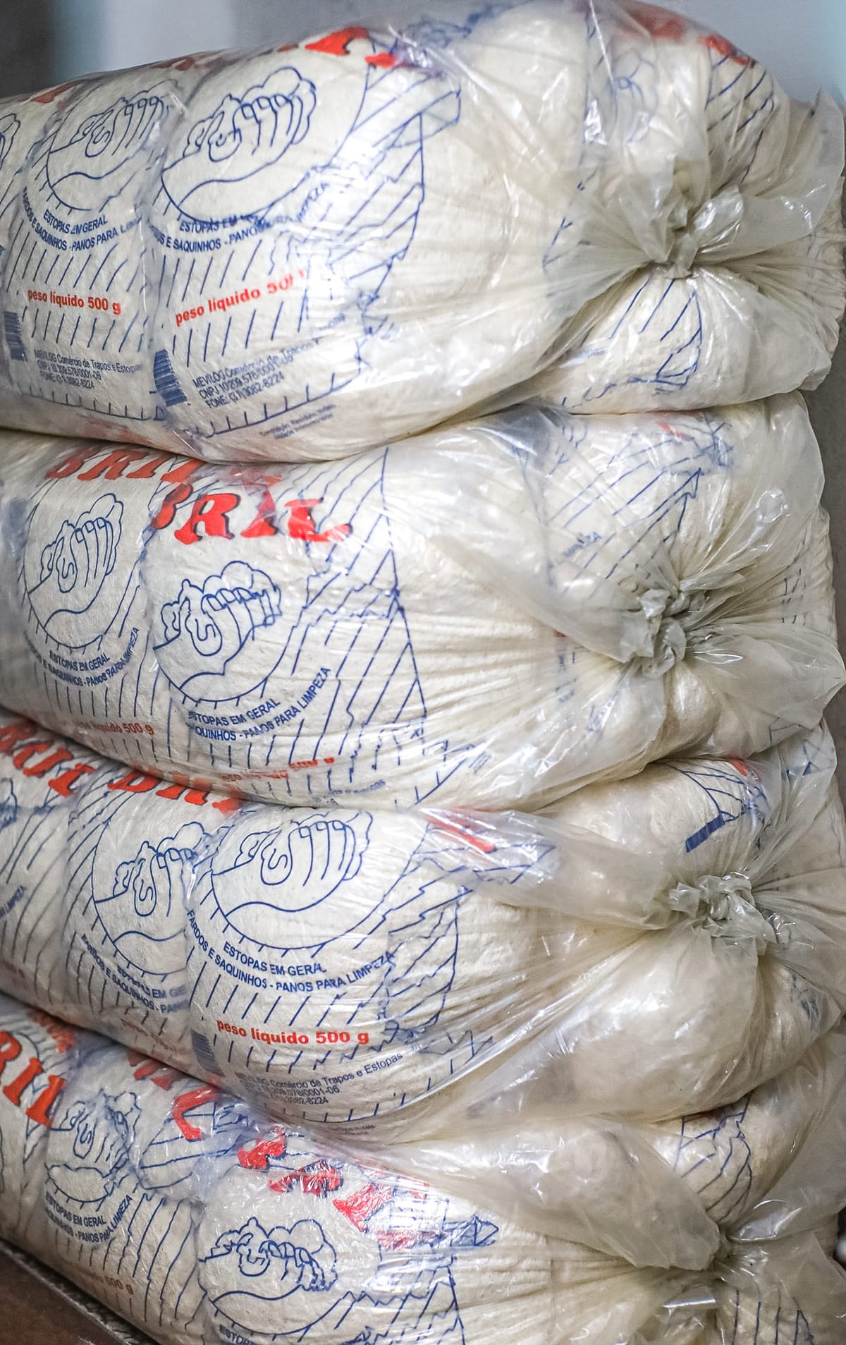 Estoque de pacotes de estopa branca Bril de 500g empilhados para pronta entrega